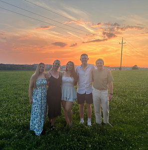 Group of travellers smiling together in the Austrian Alps during sunset