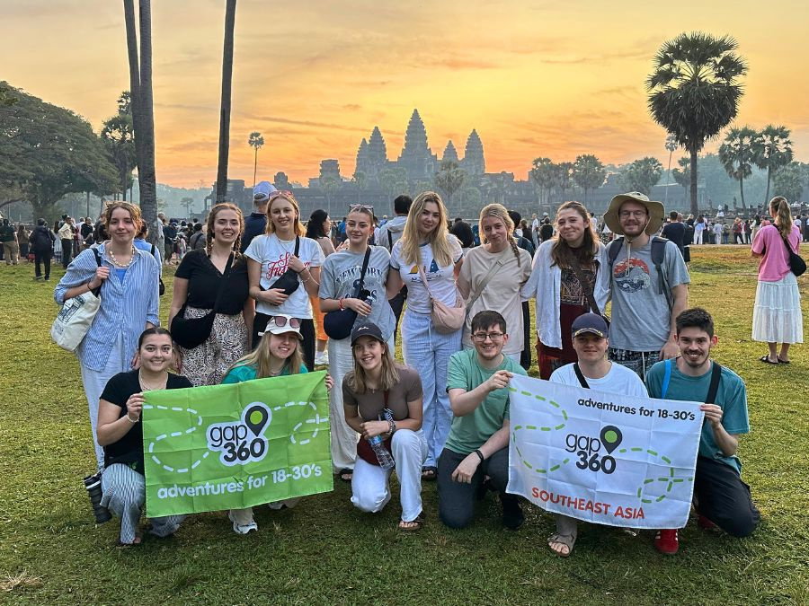 Group of travellers in front of Angkor Wat at sunrise in Cambodia