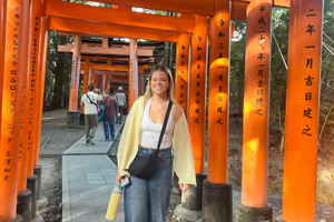 Maisie stood by orange torii gates of Fushimi Inari
