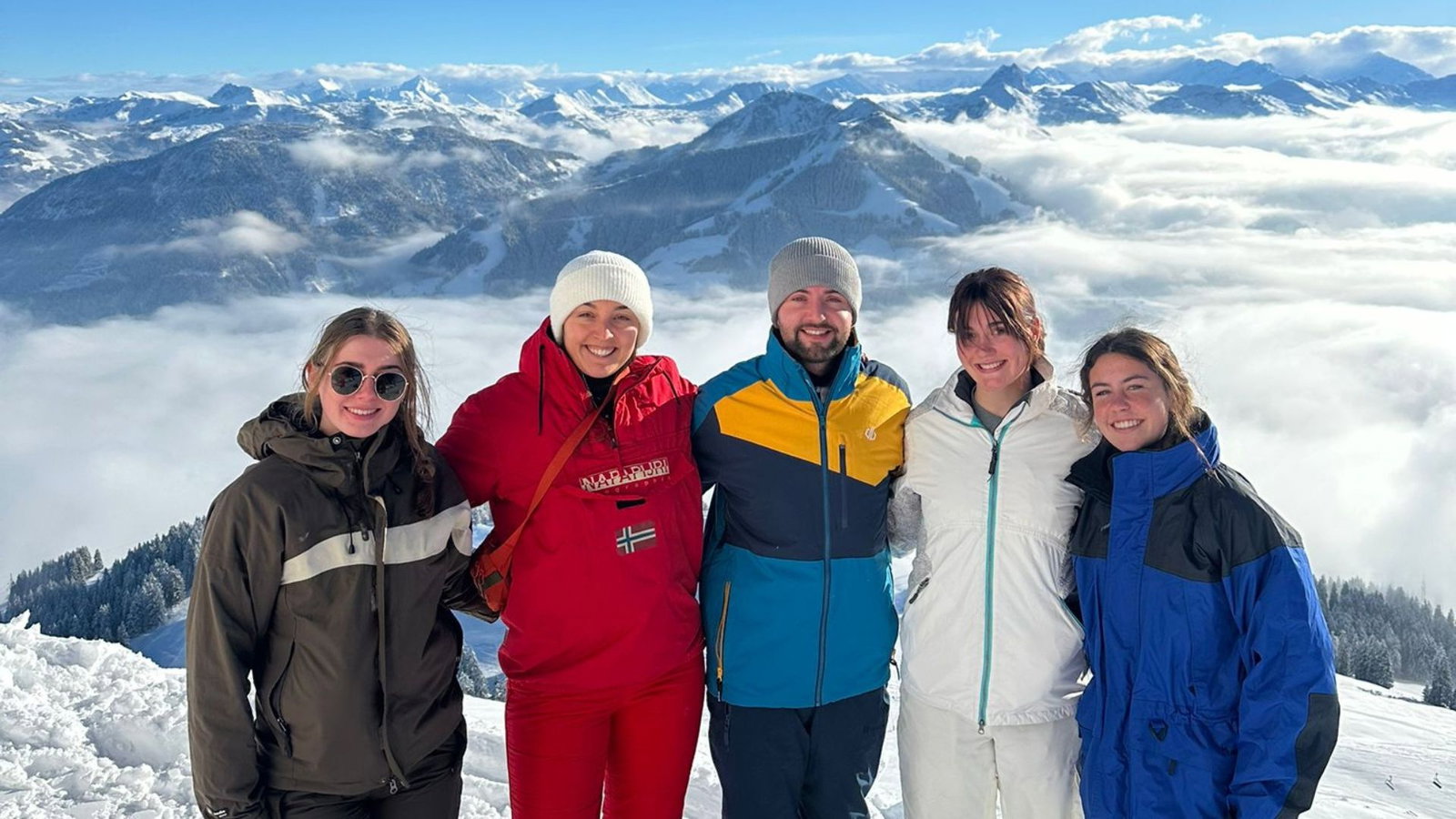 Group of skiers smiling at the top of the mountain in Austria