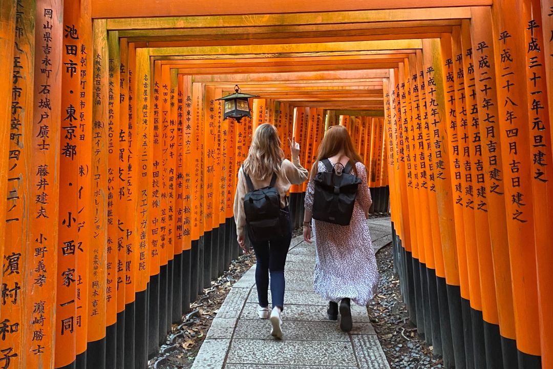 Travellers walking through Fushimi Inari Shrine
