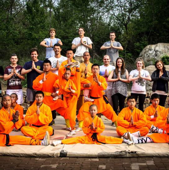 A group of travellers with Kung Fu practitioners in orange outfits