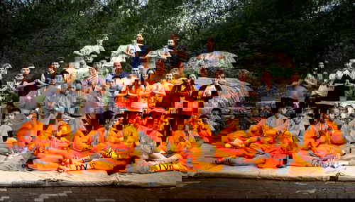 A group of travellers with Kung Fu practitioners in orange outfits