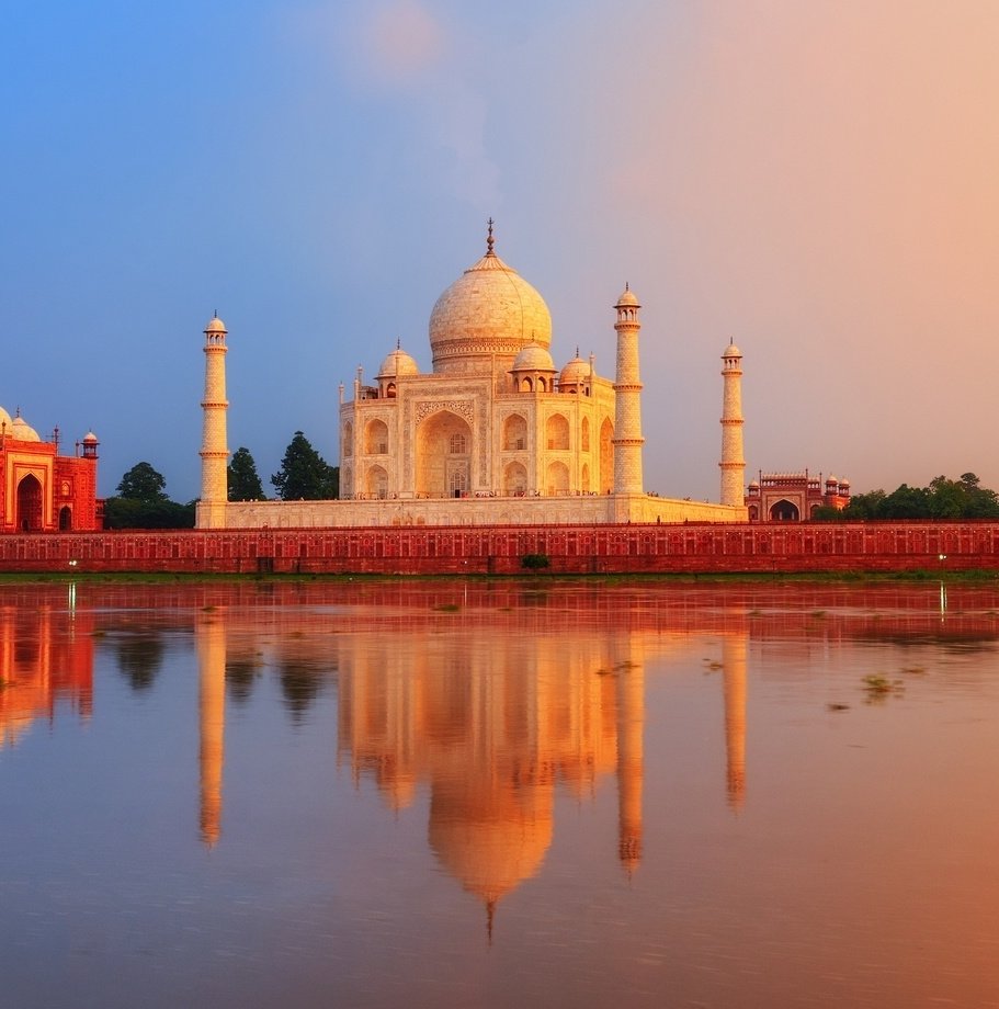 Taj Mahal behind a lake at sunrise
