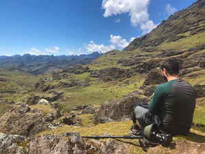 A traveller sitting on a rock overlooking mountains