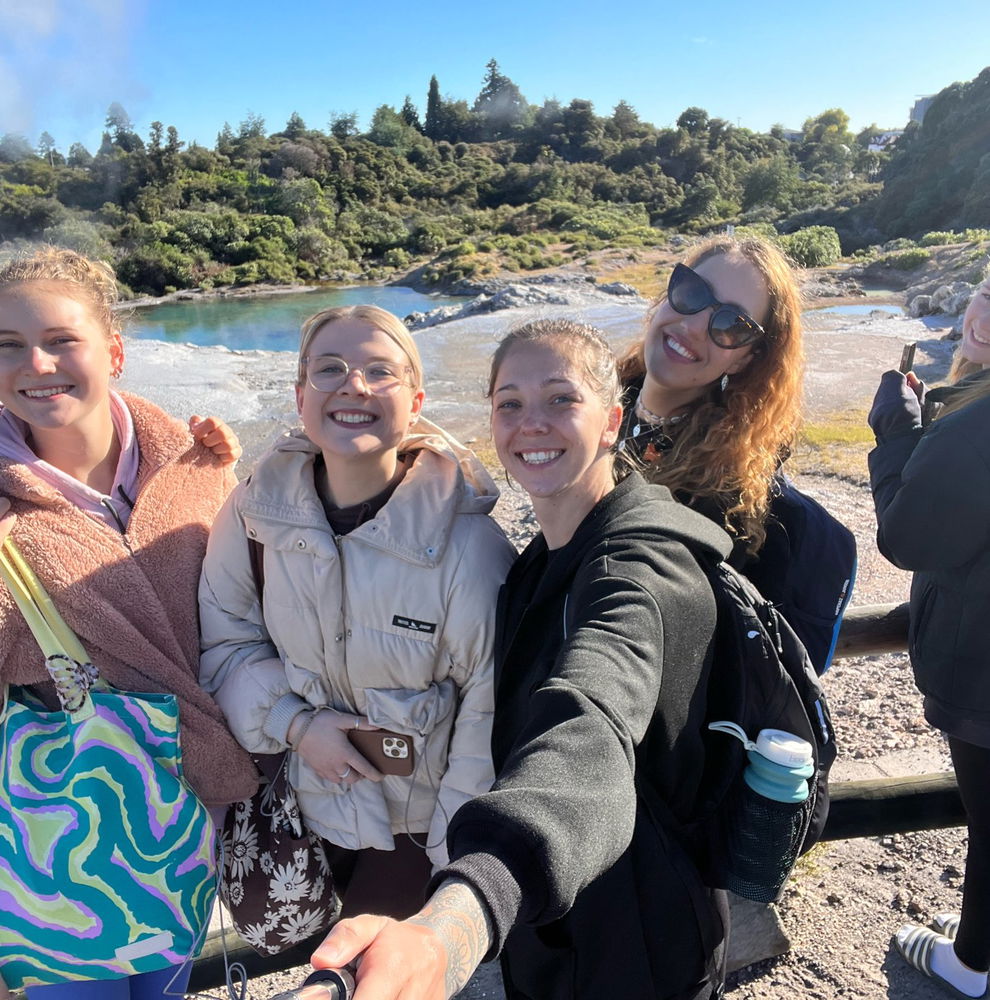 Group in front geyser in Rotorua, New Zealand