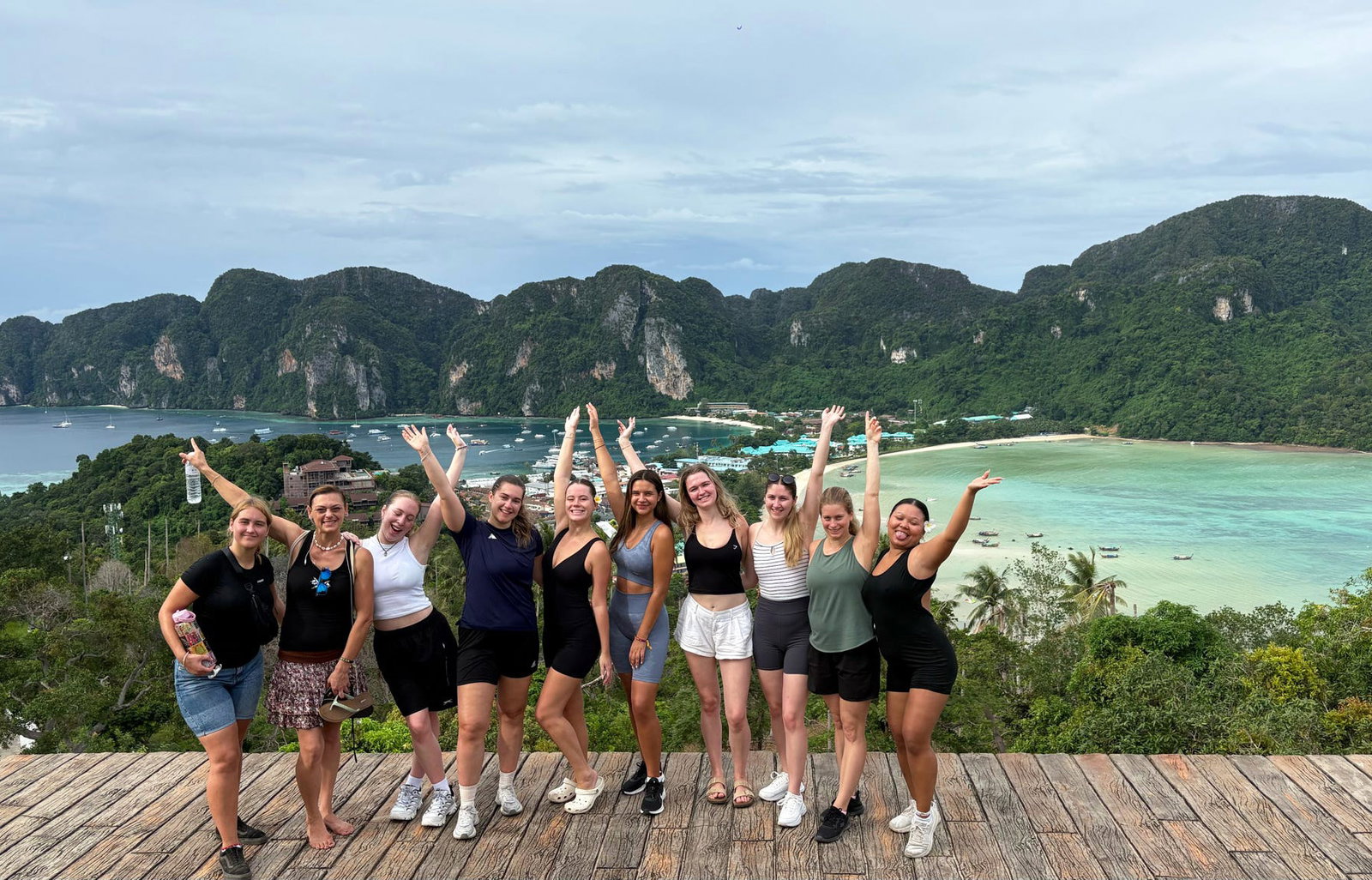 Group of travellers with arms up at Koh Phi Phi viewpoint