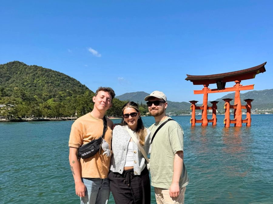 Travellers in Japan stood by Itsukushima Shrine