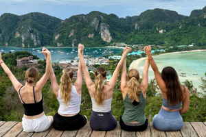 Group of travellers with arms up at Phi Phi viewpoint