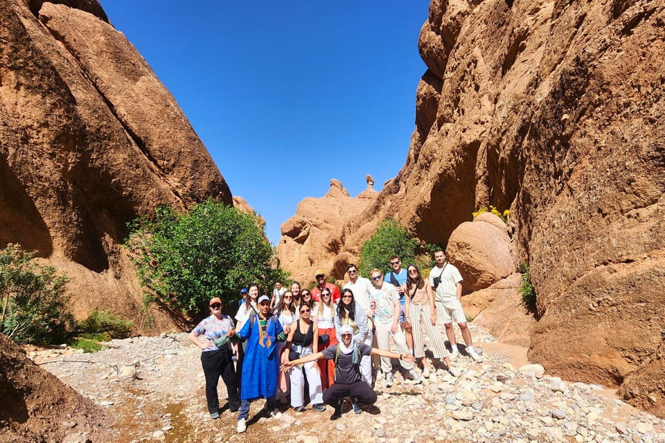 Group of travellers posing in front of limestone rocks at dades gorge