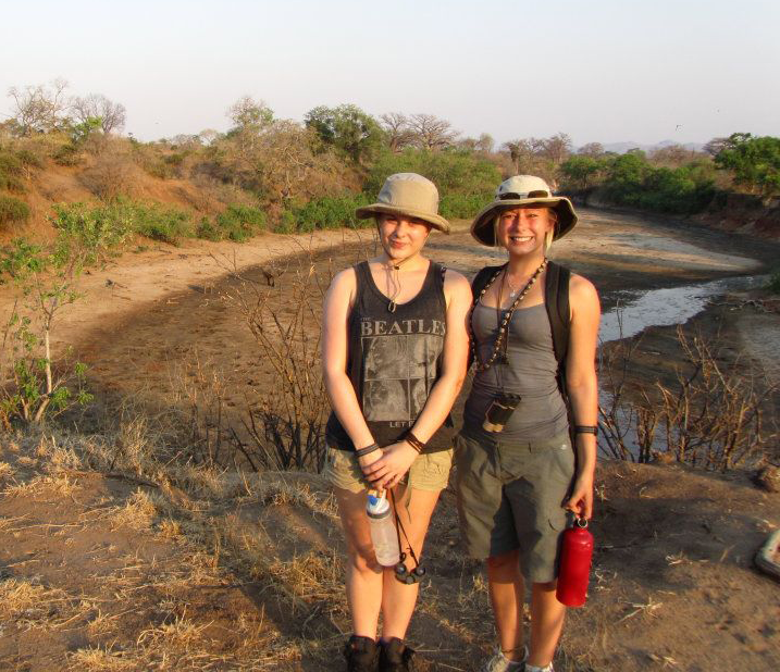 Two travellers standing in an open plain in Africa