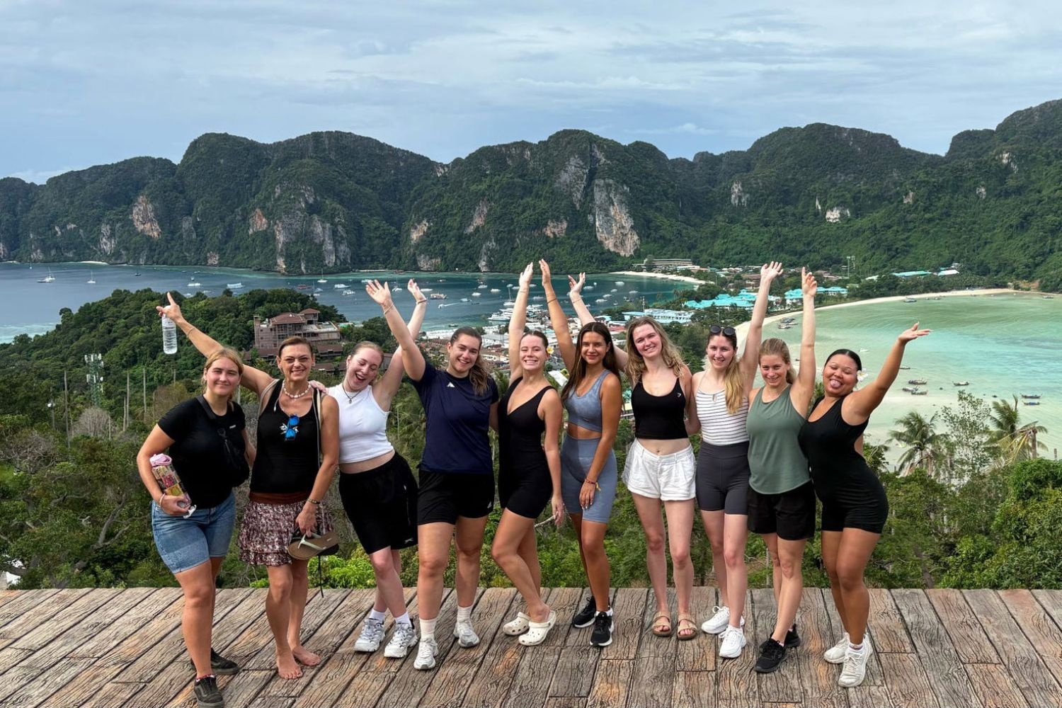 Group of travellers with arms up at Koh Phi Phi viewpoint