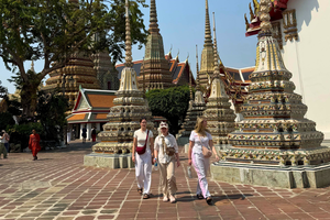 Travellers walking through traditional Buddist temple in Bangkok