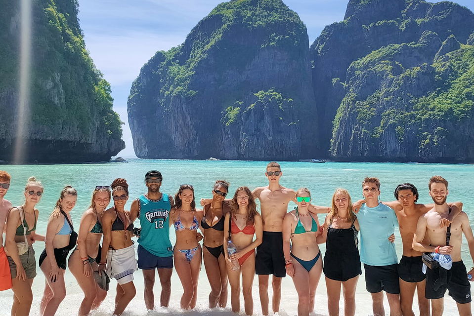 group travellers on the beach at maya bay in thailand
