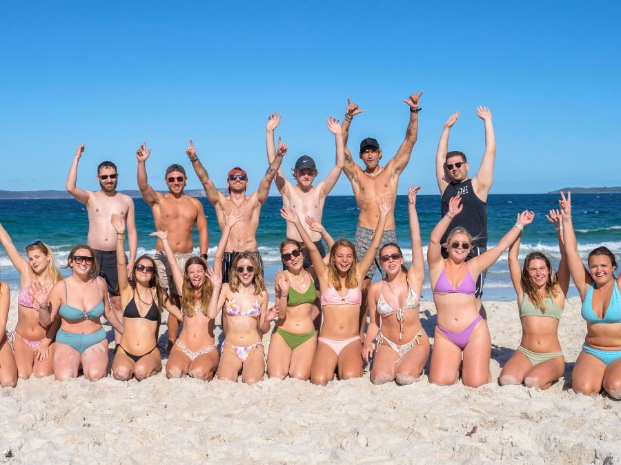 Group of travellers on sandy beach at Jervis Bay in Australia