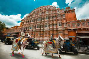 People riding horses in on Hawa Mahal Road, Jaipur, India