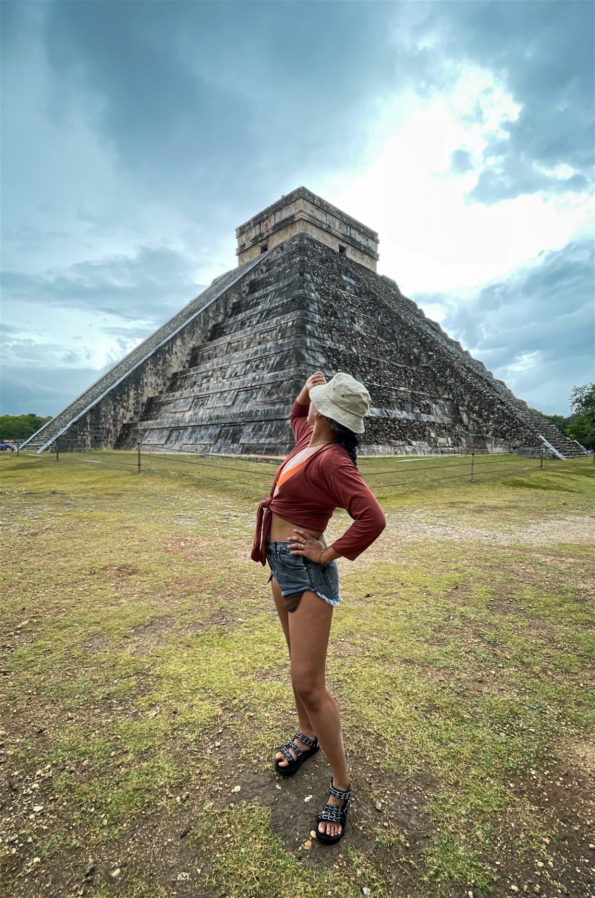 Traveller in front of Mayan temples in Chichen Itza, Mexico 
