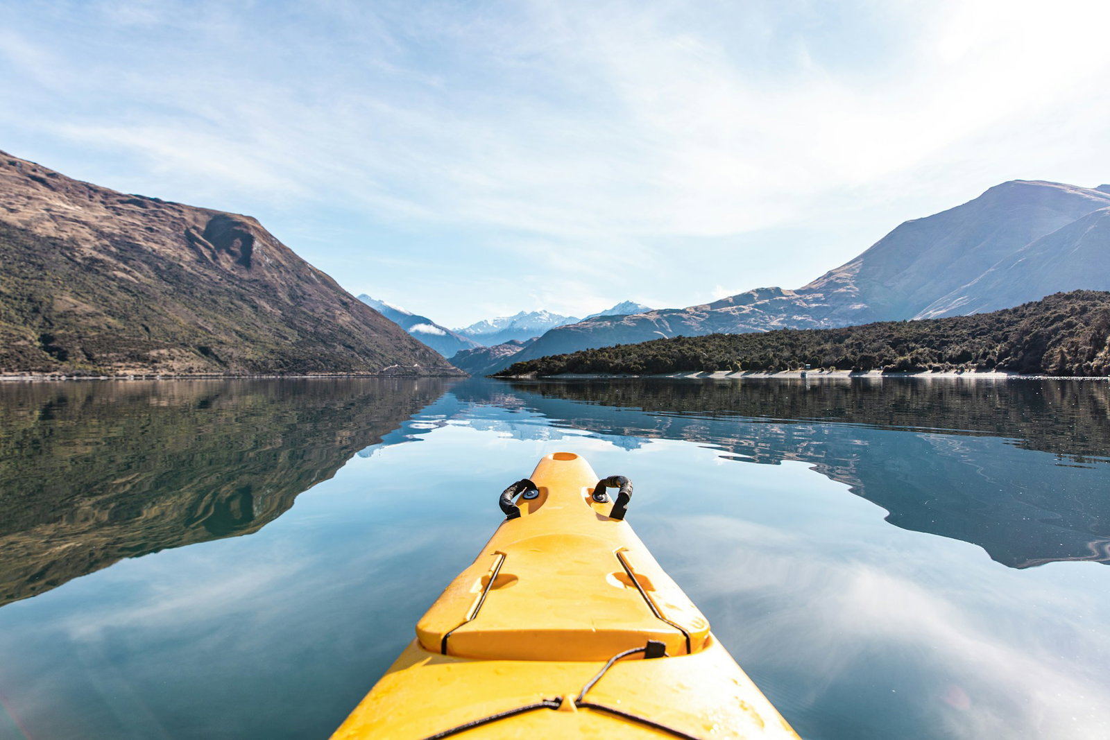 Kayaking through open lake with mountains in backdrop, Lake Wanaka