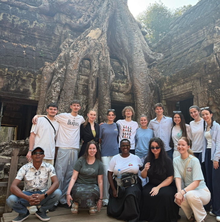 Group in Cambodia in front of an ancient tree whilst exploring Angkor Wat in Cambodia 