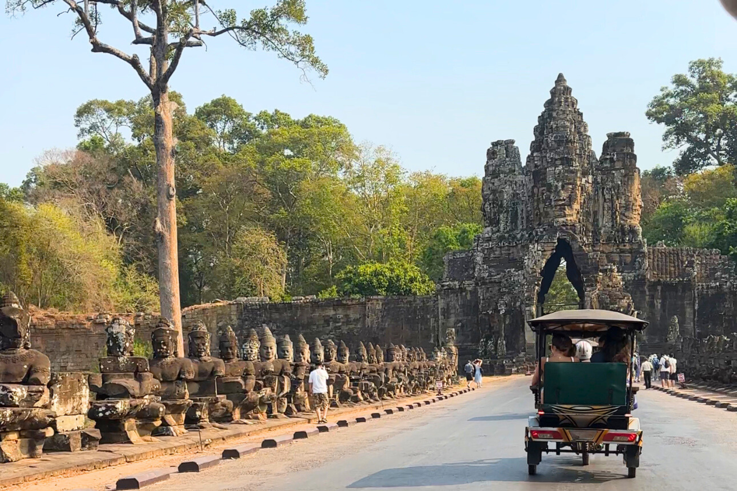 Tuk Tuk driving into the entrance of Angkor Wat in Cambodia