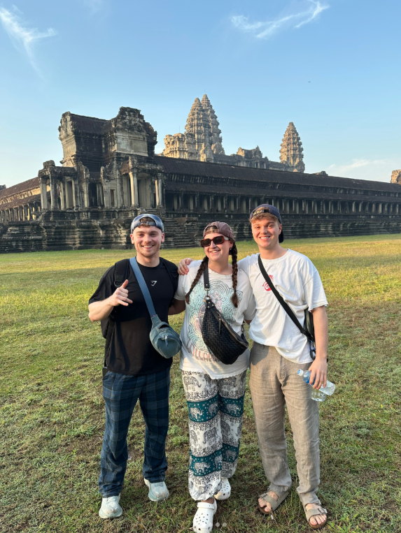Travellers stood in front of Angkor Wat at sunrise whilst on a group trip in Cambodia