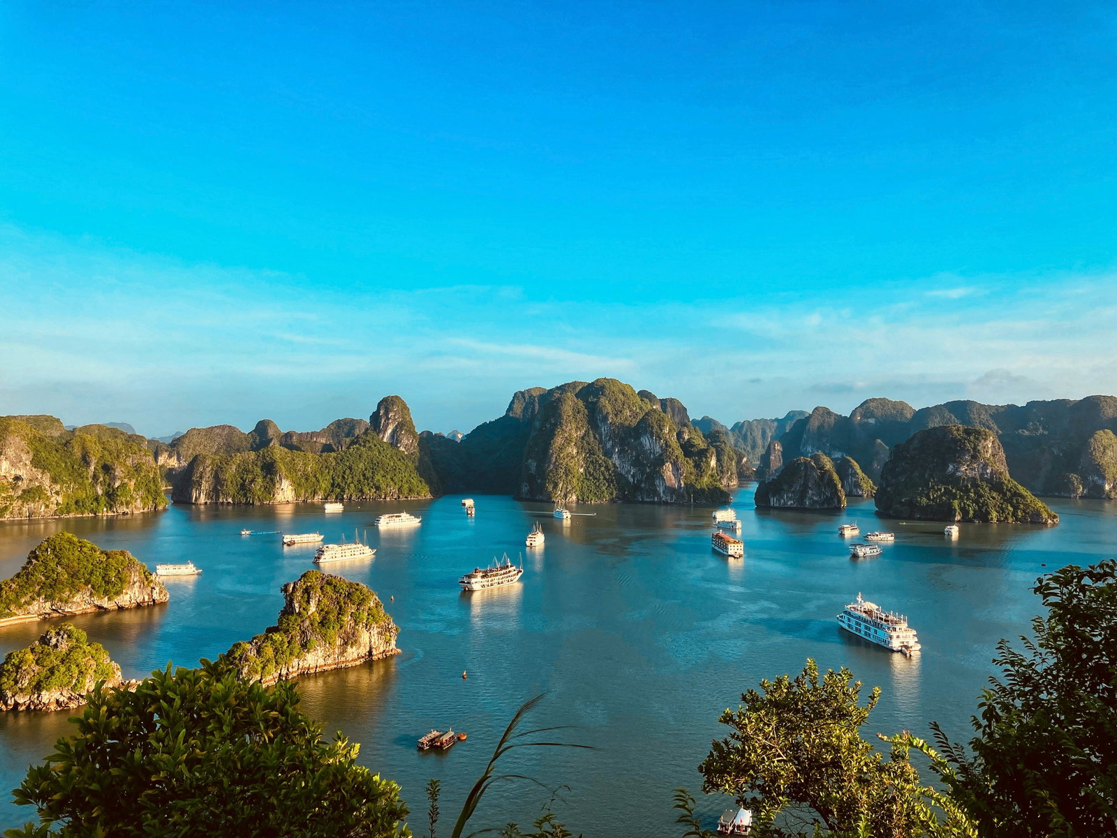 Boats sitting in Ha Long Bay in Vietnam with surrounding islands
