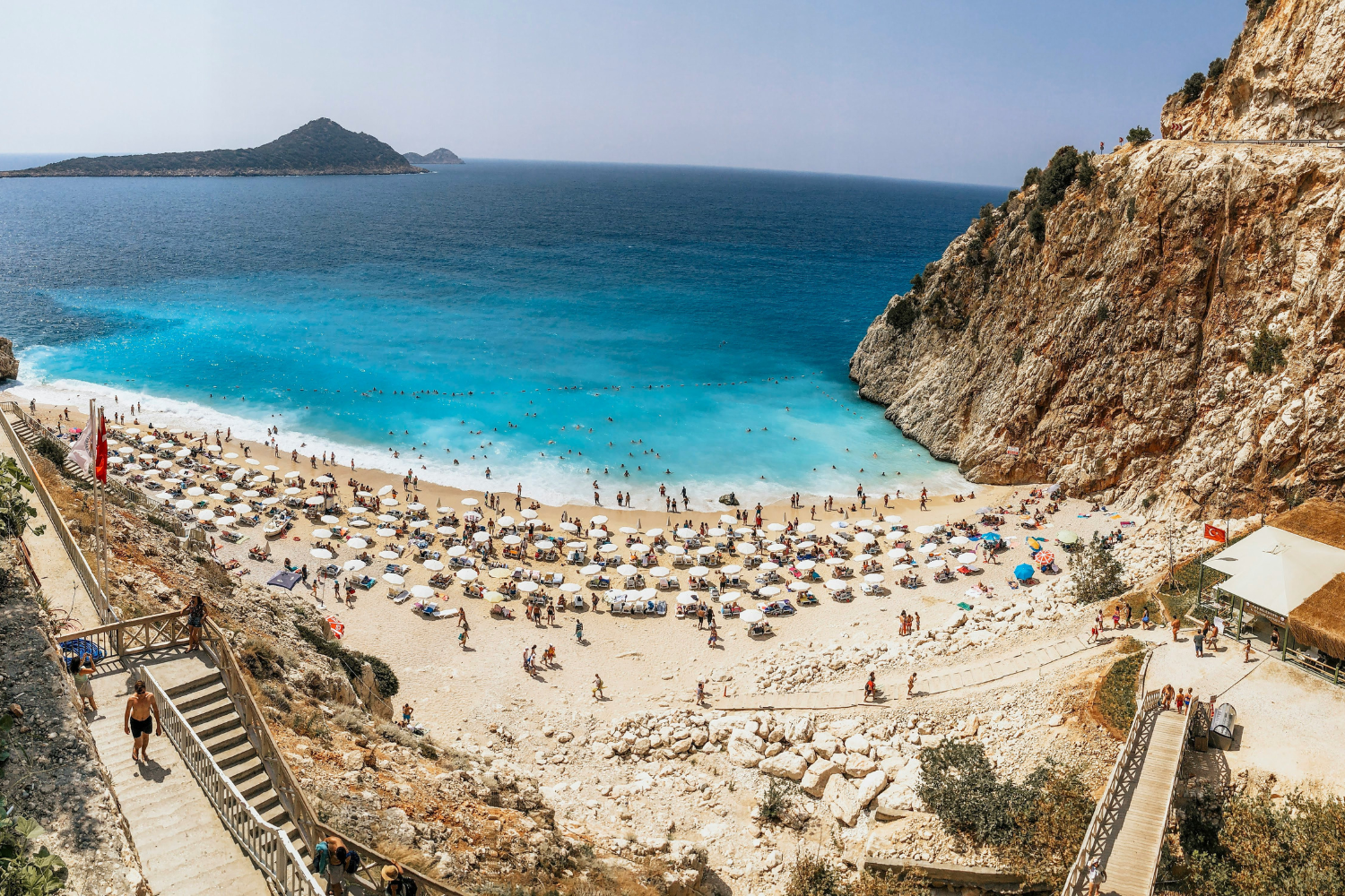 Sunbeds and umbrellas with travellers on the beach in Antalya in Turkey