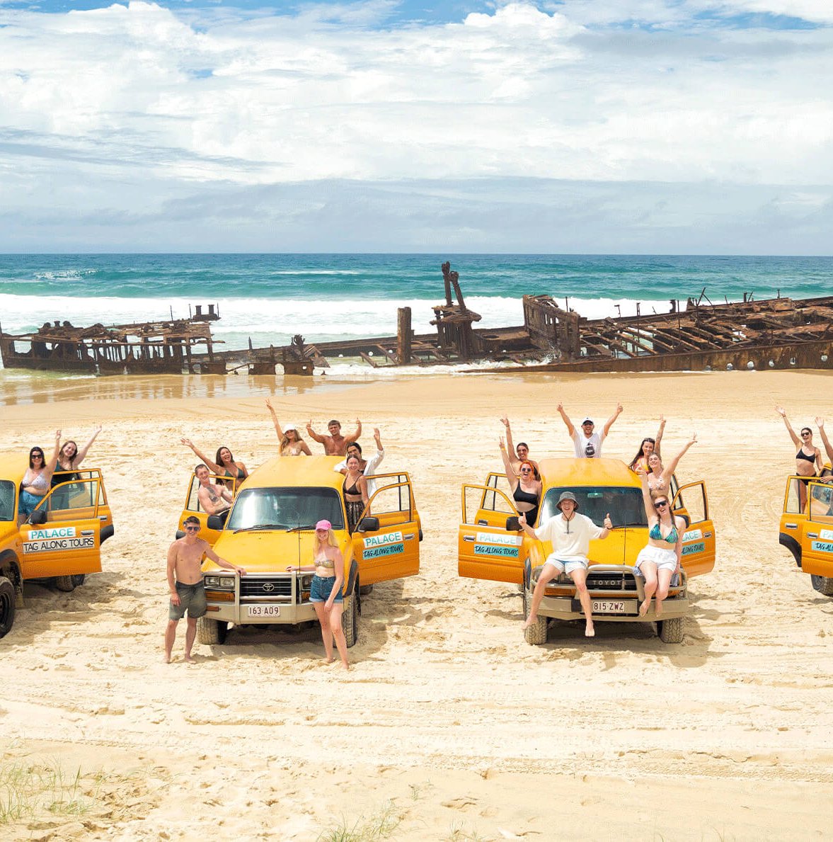 Group travellers sat on 4x4 vehicles near K'gari Shipwreak in Australia