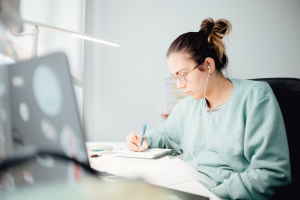 Person studying at a desk with earphones in