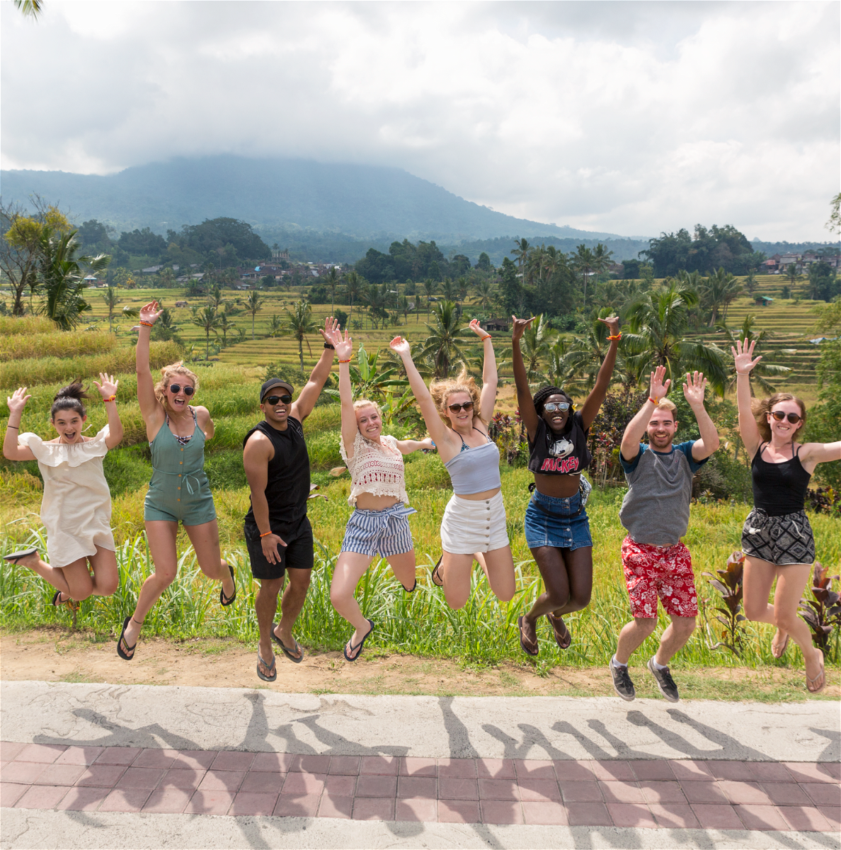 group jumping near rice paddies
