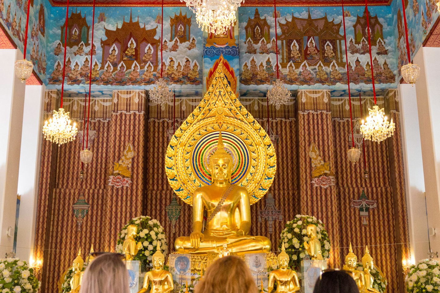 Traveller looking at golden altar in temple in Bangkok