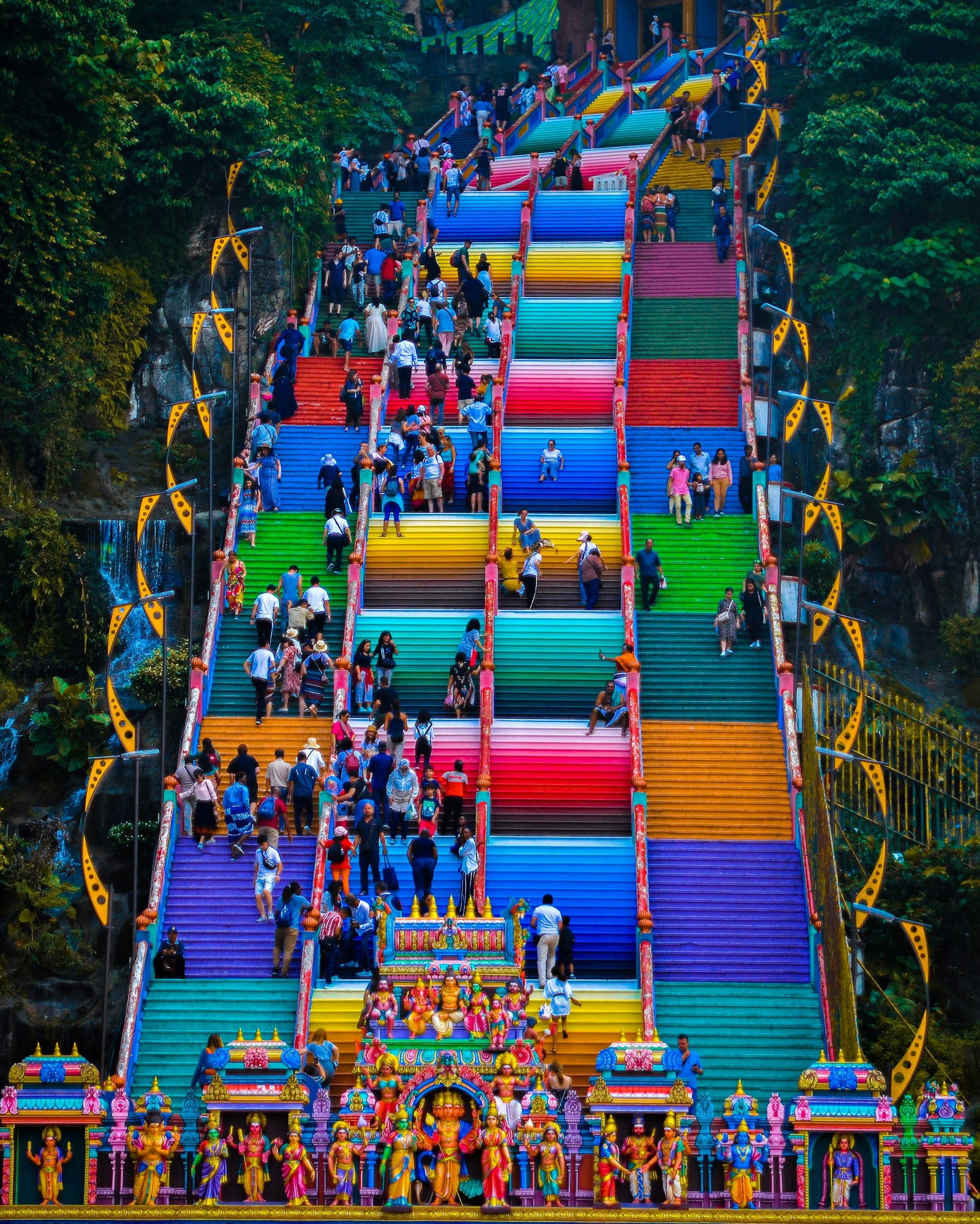 Tourists climbing and chilling on the rainbow steps of the Batu Caves outside Kuala Lumpur, Malaysia