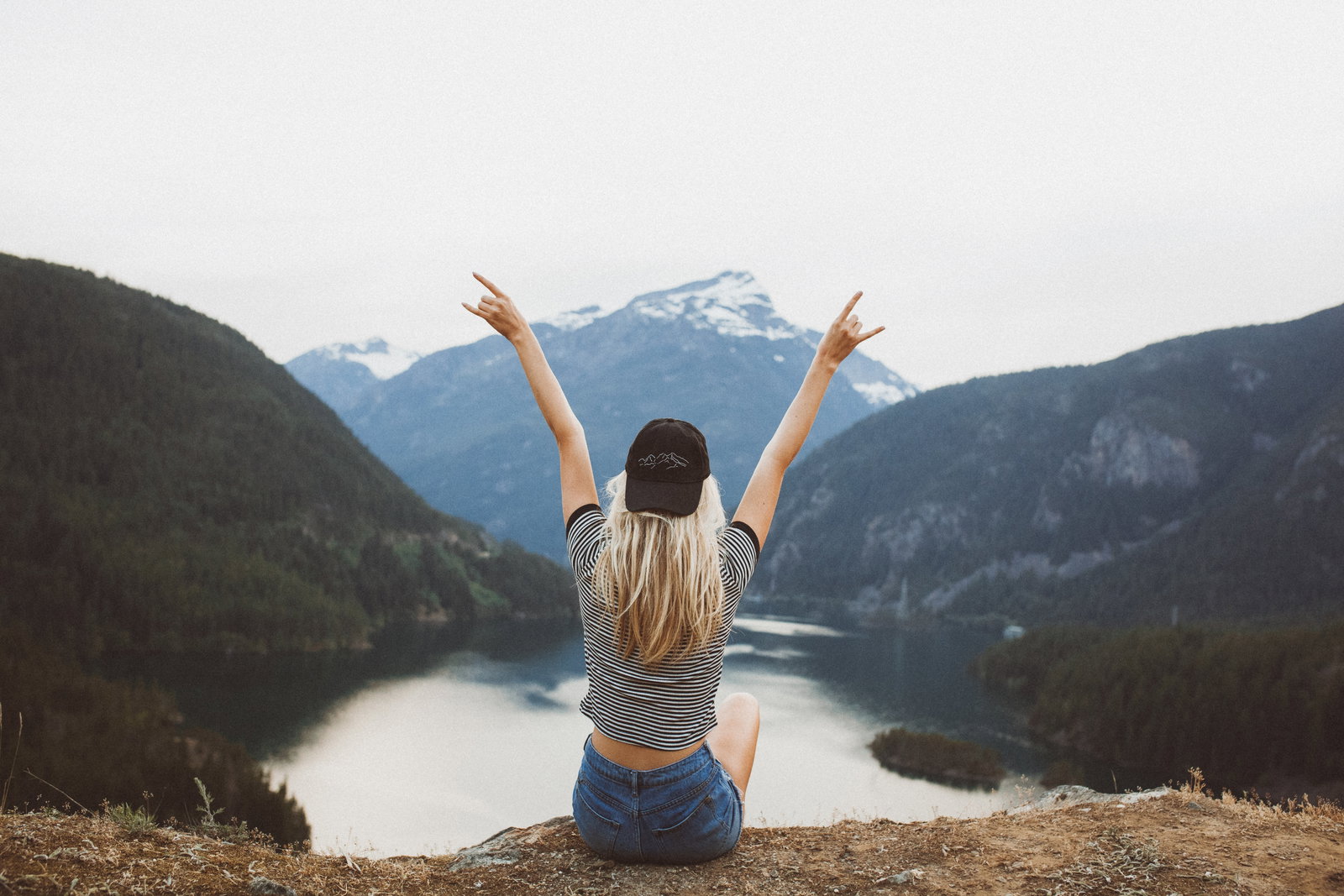 Traveller with hands up looking over Diablo Lake, United States 