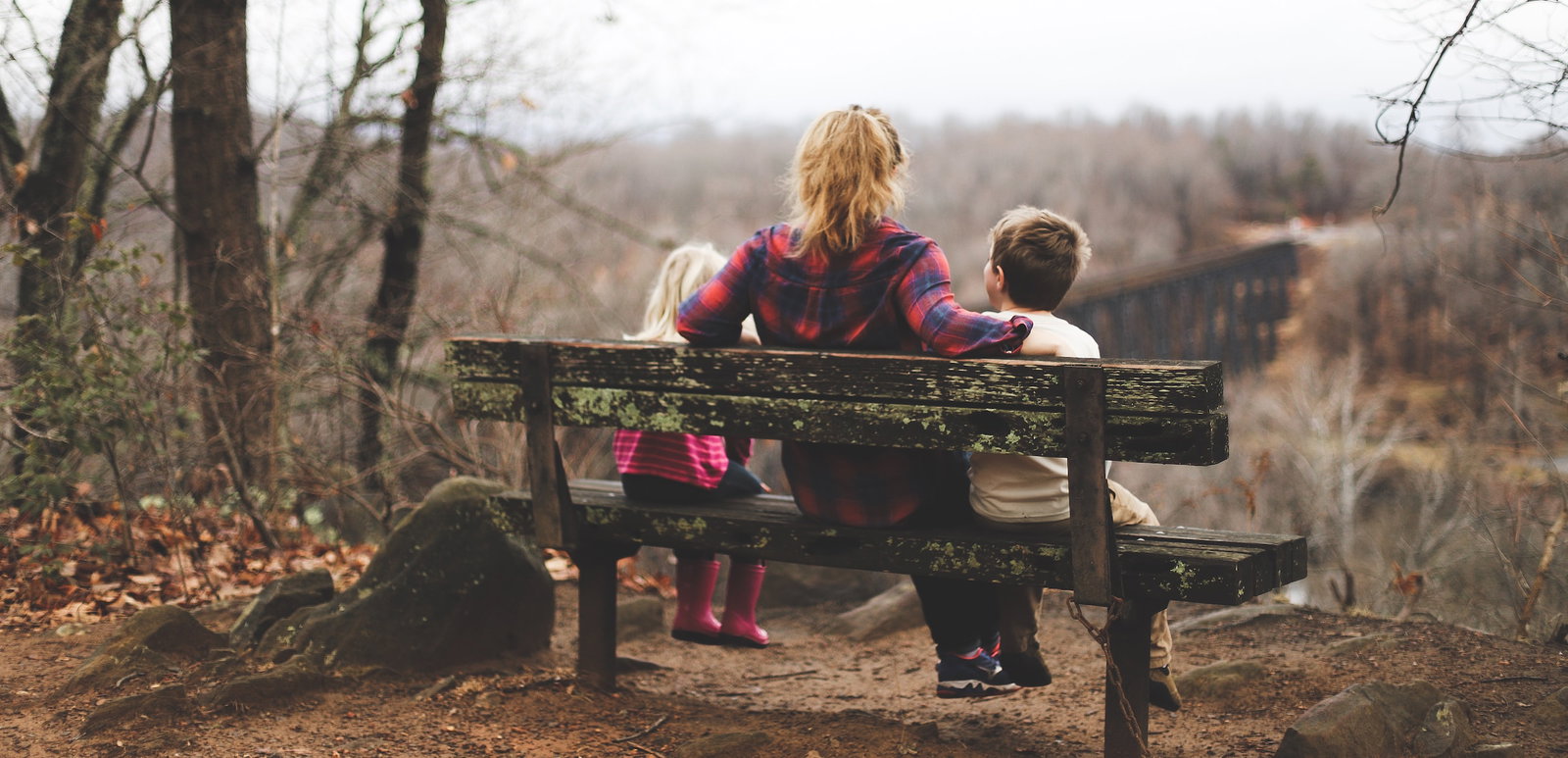 A person sitting on a bench with two children
