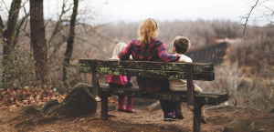A person sitting on a bench with two children