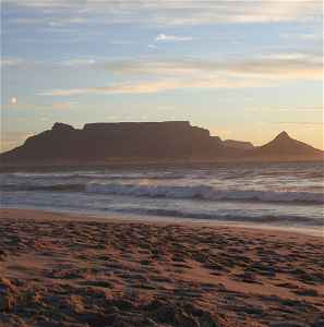 Crashing waves on a beach with Table Mountain in the background
