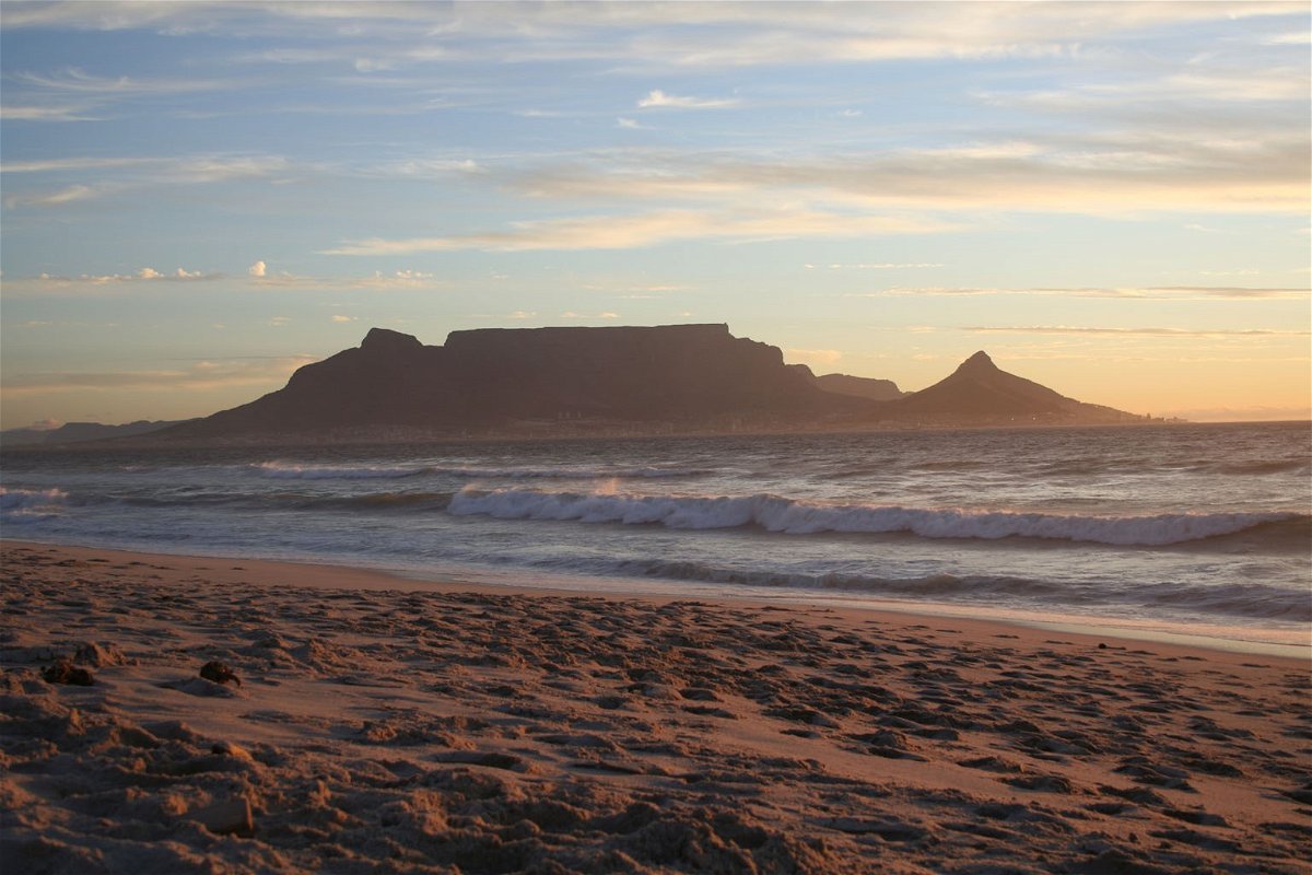 Crashing waves on a beach with Table Mountain in the background