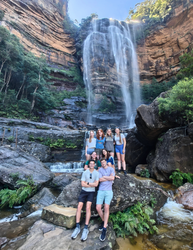Travellers sat in front of waterfall in the blue mountains in Australia