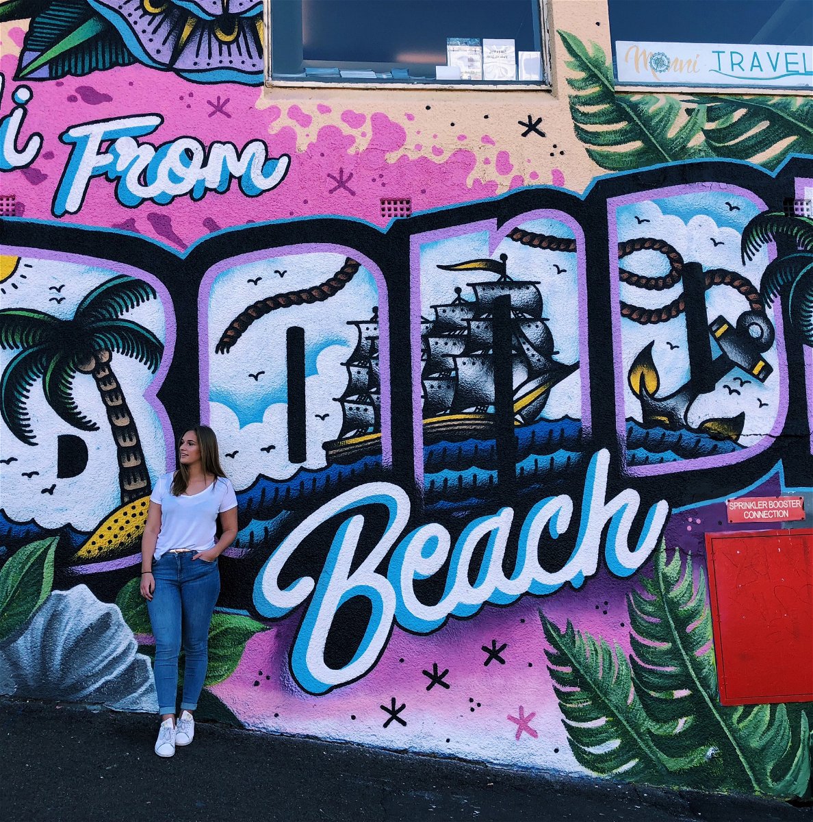 Travellers posing by a colourful graffiti art wall in Bondi Beach