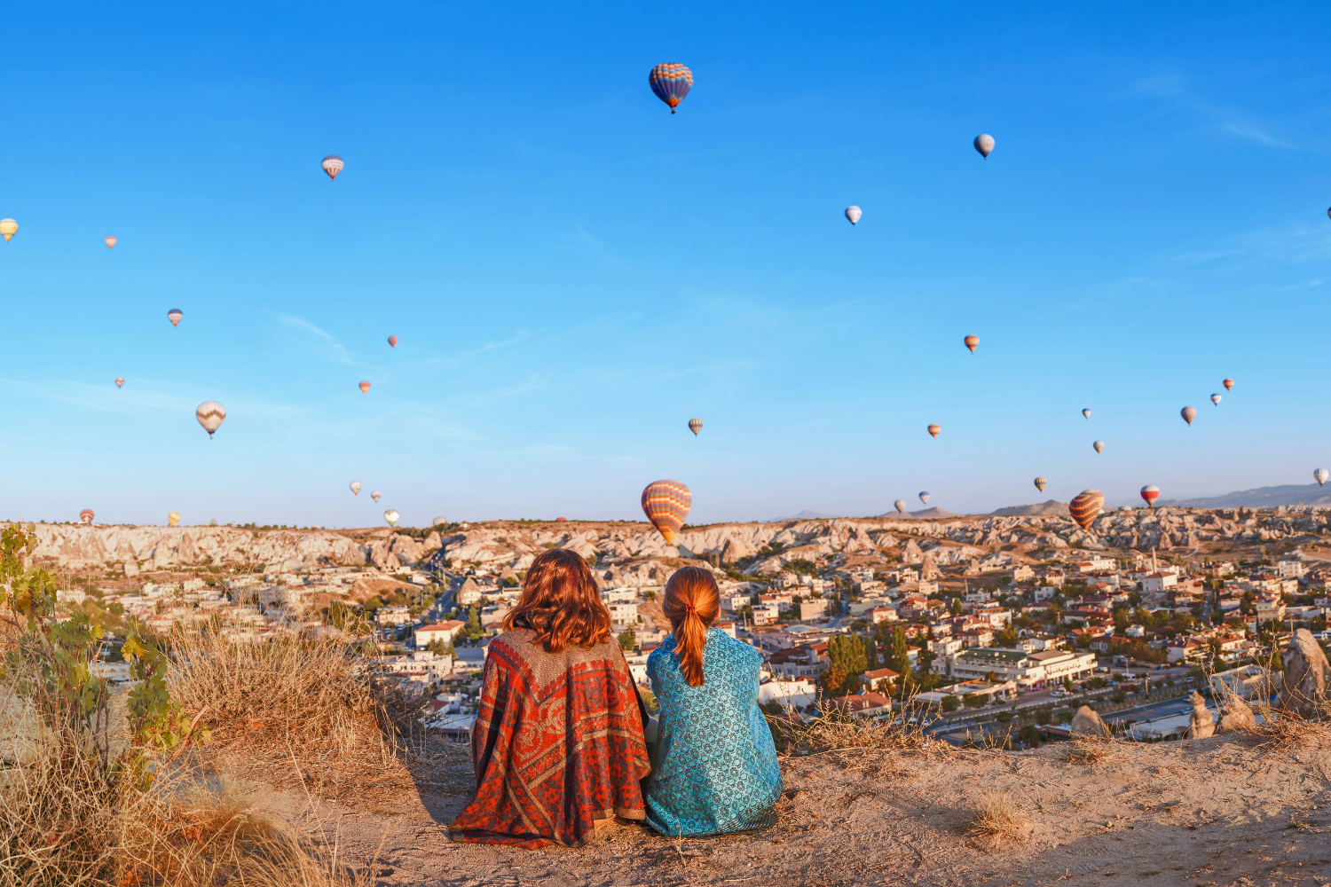 Travellers watching the Cappadocia hot air balloons across the sky in Turkey