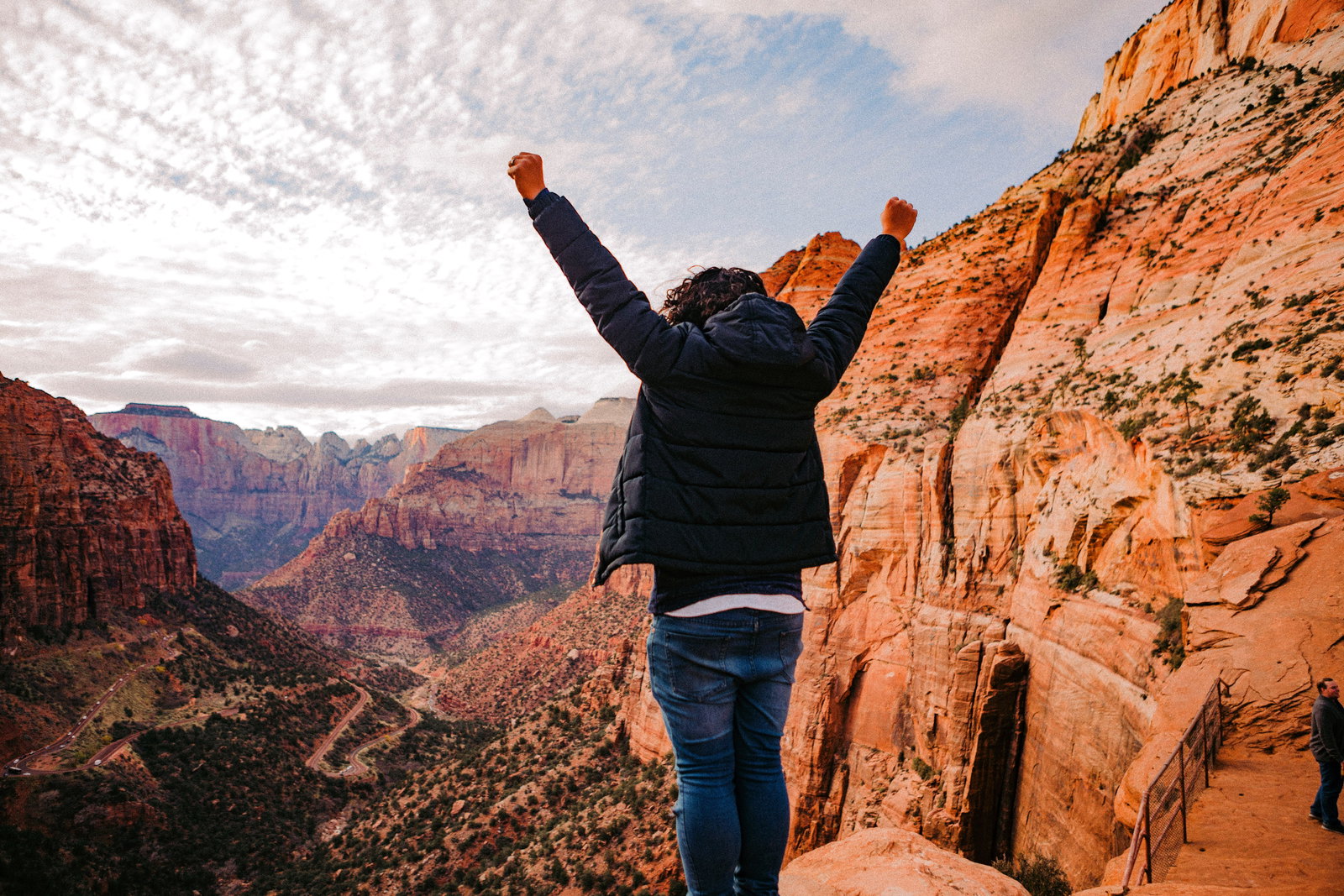 Traveller with arms up in rocky mountains