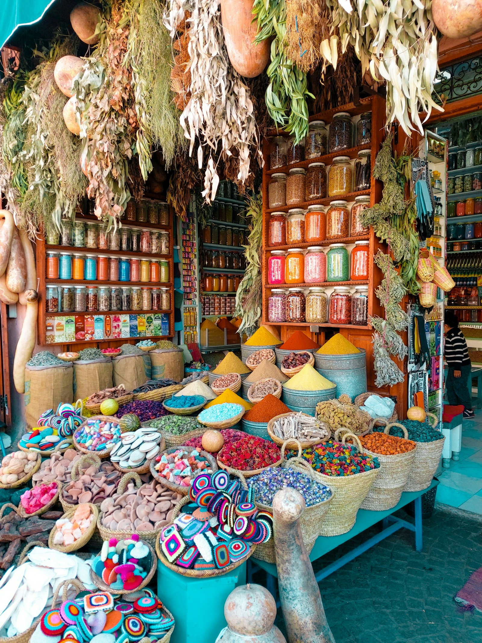 Colourful jars and bags of spices at traditional souk stall in Moroccan medina