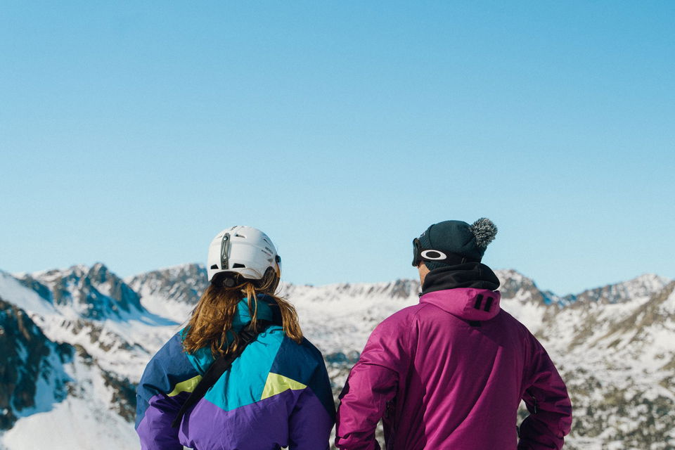 Travellers in ski equipment looking over mountains in Andorra