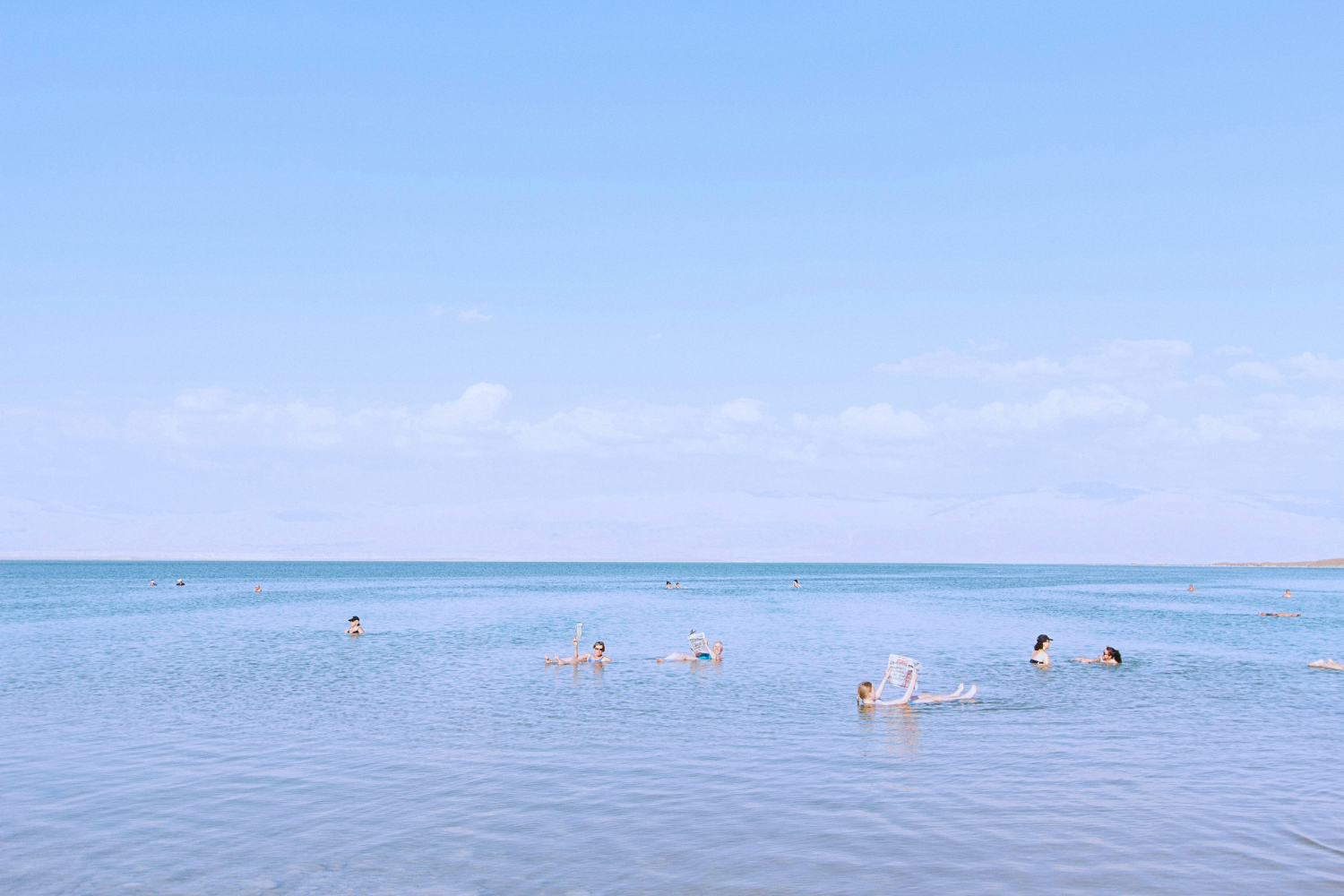 Travellers floating in the Dead Sea, with a high concentration of salt, a highlight in Jordan