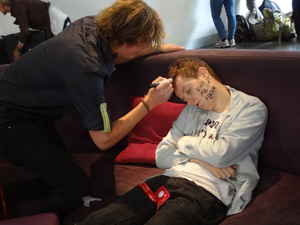 A traveller drawing on another travellers face while they sleep