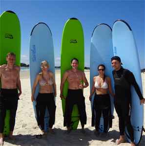 Travellers standing on a beach with surfboards