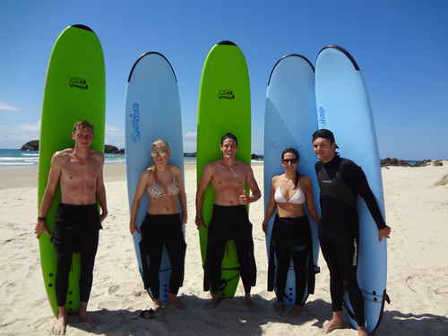 Travellers standing on a beach with surfboards