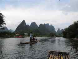 People travelling down a river on wooden rafts