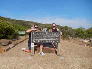 Two people behind Cape Point sign in Cape Town, South Africa 