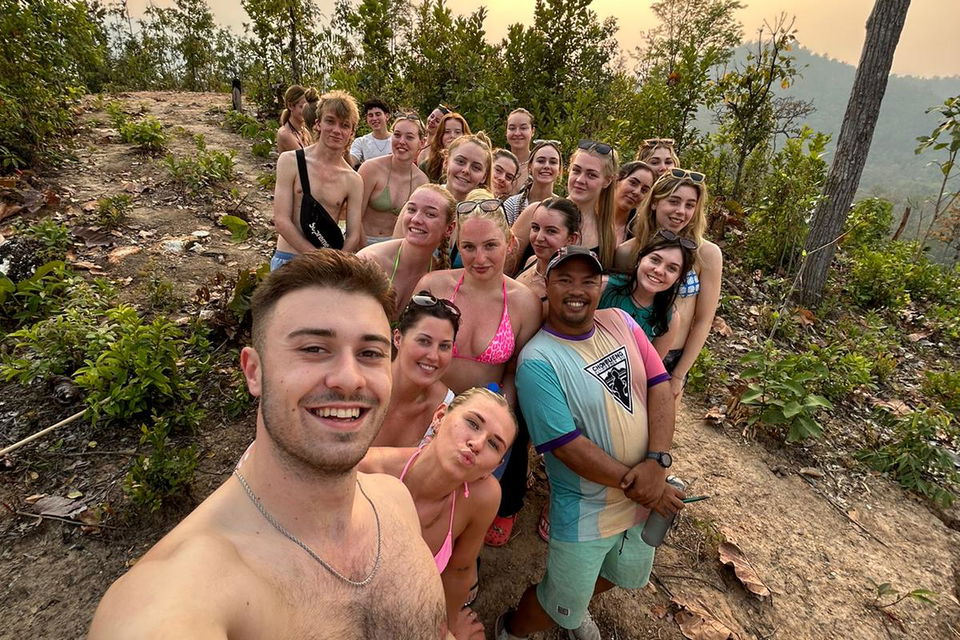 Group of travellers on hilltrek walk at sunset in thailand